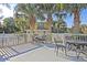 Inviting outdoor seating area surrounded by palm trees overlooking the community tennis court at 3271 Johnstowne St, Johns Island, SC 29455