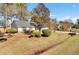 Well-maintained home featuring lush landscaping, mature trees, and a cozy, inviting front yard at 3360 Pinewood Dr, Ladson, SC 29456