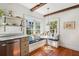 Sunlit kitchen nook featuring a window seat, round table, pendant light, and hardwood floors at 36 Bogard St, Charleston, SC 29403
