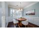 Bright breakfast nook with a round table, modern chandelier, and lots of natural light from the shuttered windows at 3711 Riverstation Ct, Mount Pleasant, SC 29466