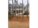 Two-story yellow home with a double-decker front porch and dormer windows at 3711 Riverstation Ct, Mount Pleasant, SC 29466