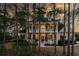 Inviting two-story yellow home with a spacious porch surrounded by trees at 3711 Riverstation Ct, Mount Pleasant, SC 29466