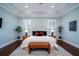 Spacious main bedroom featuring a tray ceiling, seating, and plentiful natural light from shuttered windows at 3711 Riverstation Ct, Mount Pleasant, SC 29466