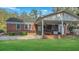 Back exterior brick home with covered patio and a well-manicured lawn with mature trees at 409 Dowling Ave, Walterboro, SC 29488