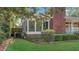 Side view of brick home with an enclosed sunroom area offering a view of the lush, green yard at 409 Dowling Ave, Walterboro, SC 29488