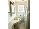 Neat bathroom featuring a white vanity with stylish fixtures, tiled floors, and a shower at 411 Maplewood Dr, Walterboro, SC 29488