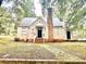 Charming single-story home featuring a brick chimney, inviting front porch, and landscaped surroundings at 411 Maplewood Dr, Walterboro, SC 29488