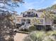Beautiful two-story home with inviting front porch, lush landscaping, and swaying palm trees at 4983 Sound View Dr, Mount Pleasant, SC 29466