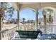 Inviting hanging swing on a covered porch with serene neighborhood views and palm tree backdrop at 4983 Sound View Dr, Mount Pleasant, SC 29466