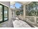 Inviting covered porch with a stone tiled floor and a view of the surrounding woods at 4983 Sound View Dr, Mount Pleasant, SC 29466