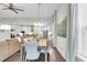 Open-concept dining room featuring a large table, modern chandelier, and flowing into the kitchen and living areas at 5049 Song Sparrow Way, Summerville, SC 29483