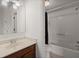 Bathroom with dark wood vanity, white walls, a shower and tub combo, and light tile floors at 509 Reserve Way, Summerville, SC 29485