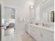 Elegant bathroom featuring a double vanity with marble countertop, decorative mirror, and tiled floors at 5742 Kiawah River Dr, Johns Island, SC 29455