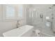 This bathroom offers a soaking tub, and a glass-enclosed shower with marble tile, and decorative stool at 5742 Kiawah River Dr, Johns Island, SC 29455