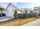 Exterior view showing a two-car garage, dark wood fence, and well-manicured landscaping for curb appeal at 5742 Kiawah River Dr, Johns Island, SC 29455