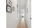 Well-lit hallway with hardwood floors and tastefully decorated walls at 5742 Kiawah River Dr, Johns Island, SC 29455