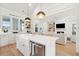 Bright kitchen with a farmhouse sink, quartz countertops, an island with pendant lighting, and open access to the living area at 5742 Kiawah River Dr, Johns Island, SC 29455