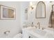 Chic powder room with gold fixtures, decorative mirror, and stylish lighting for an elegant touch at 5742 Kiawah River Dr, Johns Island, SC 29455
