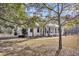 Charming exterior with white brick, metal roof, lush landscaping and an inviting front porch at 6294 Highway 165, Ravenel, SC 29470