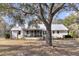 Exterior of home featuring a metal roof, screened porch, patio and expansive backyard with mature trees at 6294 Highway 165, Ravenel, SC 29470