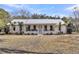 Charming single-story home with a metal roof and inviting front porch, surrounded by palm trees at 6294 Highway 165, Ravenel, SC 29470