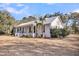 Charming single-story home with a metal roof and inviting front porch, surrounded by mature trees at 6294 Highway 165, Ravenel, SC 29470