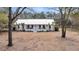 Inviting white home featuring a covered front porch, metal roof, and neatly landscaped yard at 6294 Highway 165, Ravenel, SC 29470