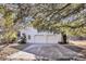 Detached two-car garage with white doors and concrete driveway surrounded by a wooded area at 6294 Highway 165, Ravenel, SC 29470