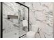 Bathroom with a glass enclosed shower over a tub, accented with marble tiling from floor to ceiling at 721 Meeting St, Charleston, SC 29403