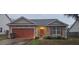 Charming single-story home with a stone facade and a red garage door provides curb appeal at 7646 Kinston St, North Charleston, SC 29418