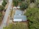 Aerial view of a well-maintained property with a home, shed, and driveway surrounded by trees at 907 Pauline Ave, Charleston, SC 29412