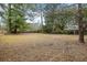 Spacious fenced backyard featuring dormant grass and mature trees, creating a private outdoor space at 907 Pauline Ave, Charleston, SC 29412