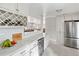 Well-appointed kitchen with wine storage, marble counters, stainless steel refrigerator and view to the living room at 907 Pauline Ave, Charleston, SC 29412
