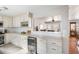 Beautiful kitchen features white cabinetry, marble counters, wine storage, and a view into the living area at 907 Pauline Ave, Charleston, SC 29412