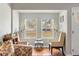 Bright sitting area featuring hardwood floors, two cushioned chairs, lamps and large windows overlooking the outdoors at 907 Pauline Ave, Charleston, SC 29412