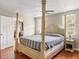 Comfortable bedroom features a four post bed, ceiling fan, hardwood floors, and a view to the outdoors at 907 Pauline Ave, Charleston, SC 29412