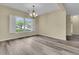 Open dining room featuring wood floors, a chandelier, and a large window with neighborhood views at 101 S Gateshead Crossing, Goose Creek, SC 29445