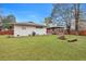 Expansive backyard featuring lush green grass, a screened-in porch, mature trees, and a fire pit area at 1228 Brookside Dr, Hanahan, SC 29410