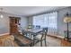 Charming dining room with wood table, bench, upholstered chairs, and decorative sheer curtains at 1228 Brookside Dr, Hanahan, SC 29410