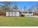 Charming one-story white home featuring a well-maintained lawn and unique architectural details at 1228 Brookside Dr, Hanahan, SC 29410
