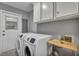 Well-equipped laundry room with modern washer and dryer, cabinets, and ample space at 1228 Brookside Dr, Hanahan, SC 29410
