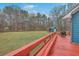 Large, green backyard with a view from the red painted wooden deck, ideal for outdoor living at 131 Londonderry Rd, Goose Creek, SC 29445
