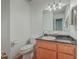 A functional bathroom featuring a wood vanity with dark countertop, a toilet, and well-lit mirror at 131 Londonderry Rd, Goose Creek, SC 29445