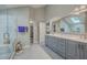 A bright bathroom with dual sinks, vanity, and a glass-enclosed shower, plus a walk-in closet at 131 Londonderry Rd, Goose Creek, SC 29445