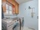 A well-equipped laundry room with a modern washer and dryer, and ample storage in the wooden cabinets at 131 Londonderry Rd, Goose Creek, SC 29445