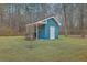 Charming blue storage shed with a white door and a well-maintained lawn at 131 Londonderry Rd, Goose Creek, SC 29445
