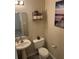 Well-lit bathroom features a pedestal sink, toilet, and decorative shelving with plants at 1320 Garland St, North Charleston, SC 29420