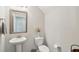 Neutral half bathroom featuring a pedestal sink, decorative mirror, and elegant floral arrangement at 1413 Tannery, Johns Island, SC 29455