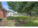 Large backyard with a mature tree shading the house and a small storage building at 1418 Kentwood Circle Cir, Charleston, SC 29412