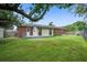 Lush backyard with a brick patio, mature trees, and view of the home's extension at 1418 Kentwood Circle Cir, Charleston, SC 29412
